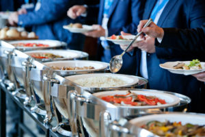 men in blue suits choosing food at a banquet
